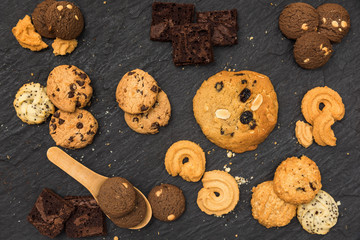 Top view different cookies on table top, Flat lay of various cookies on black stone for background, Prepared cookies food buffet on table for serve