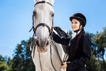 Foto op Canvas Beautiful rider. Beautiful dark-eyed female rider with fishtail standing near her gentle white horse © Viacheslav Yakobchuk