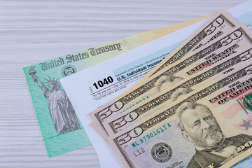 The tax 1040 forms with the money and the pen.