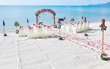 Wedding venue settings on the beach, Bunch of roses petal on the aisle, beautiful sea view...