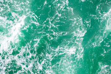 surface of turquoise ocean water with white foam, background, texture