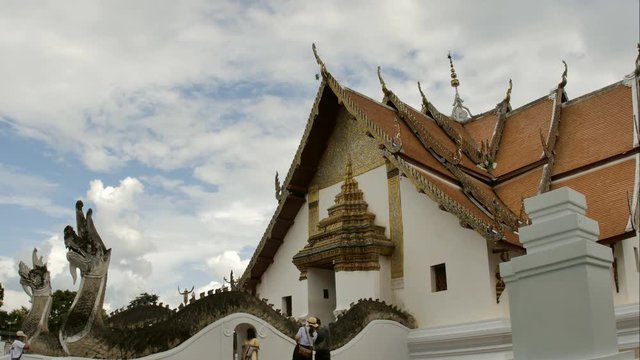 Time Lapse of White fluffy clouds in the blue sky and Buddhist temple of Wat Phumin in Nan, Thailand background