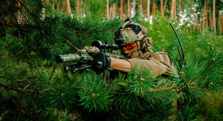 Airsoft man with optical sight gun. Soldier hidden into spruce branches on forest territory.