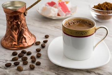 Vintage cup of turkish coffee and traditional bronze coffee pot served on marble with turkish...