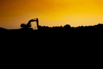 Silhouette of a excavator in the sunset