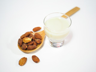 Almond in wooden spoon and glass of almond milk best for health, healthy concept