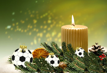 Weihnachtsdekoration mit Kerze und Fussball-Weihnachtskugeln