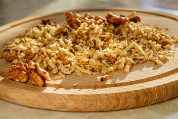 On a cutting board finely chopped walnuts for icing. Closeup view.