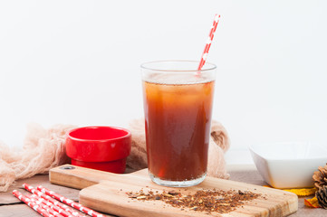 Glass of iced tea with ice cubes and a paper straw