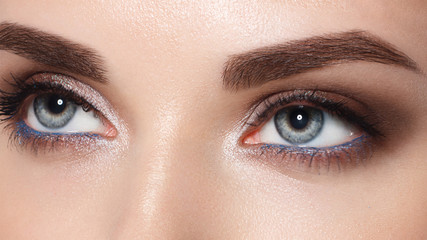 Obraz premium Close-up portrait of sexy young woman with beautiful blue eyes. Woman beauty face portrait with healthy skin. Portrait of beautiful young woman looking at camera. Natural beauty concept