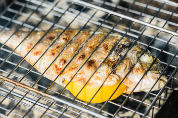 Fresh gold-plated fish on the grill. Cooking in the outdoors.