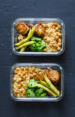 Healthy lunch box - spicy couscous with chickpeas, broccoli, green beans and turkey meatballs on dark background, top view. Copy space