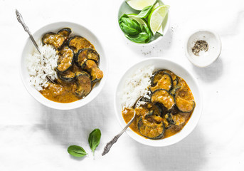 Roasted aubergine curry with rice on a light background, top view. Indian vegetarian cuisine. Flat lay