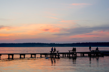 Fototapeta na wymiar Sunset over the fishing pier at the lake in rural Poland.