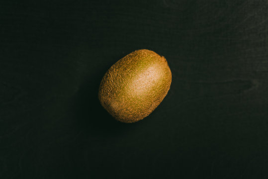 Kiwi fruit lying on black table in background with blank space as flat lay