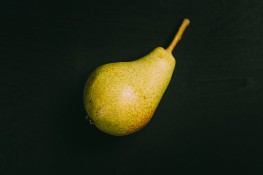 Pear lying on black table in background with blank space as flat lay
