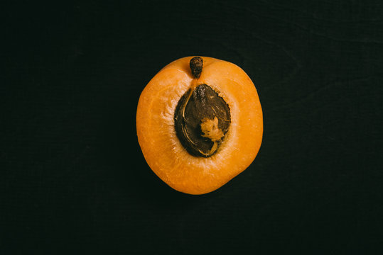 Cut peach lying on black table in background with blank space as flat lay