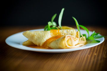 sweet thin pancakes with jam in a plate