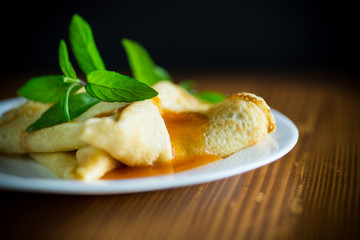 sweet thin pancakes with jam in a plate
