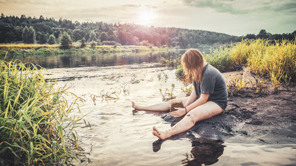 Girl building sand castles on the riverbank.