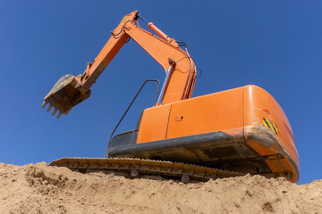 Excavator at the construction site loads the sand