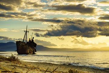 Rusty broken shipwreck on sea shore