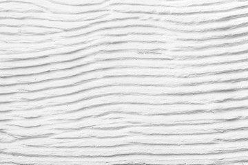 Fototapeta na wymiar White plaster cement structure with relief curved strips. Background texture of horizontal cement uneven wavy strips