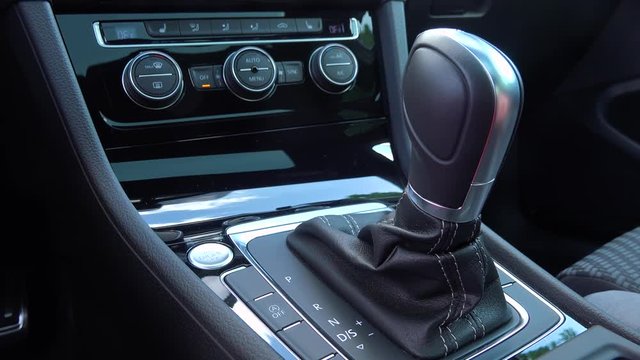 A man moves a gearshift to D in a car - closeup
