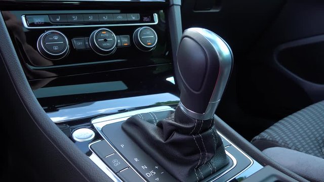 A man moves a gearshift to sport mode in a car - closeup