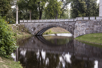 Fototapeta na wymiar An old stone bridge over the water