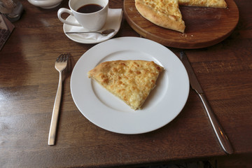 Slice of tasty cheese pizza on a white plate in a restaurant, Italian traditional appetizer.