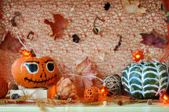 Painted pumpkins for Halloween, the falling leaves and chestnut trees with lights garlands. Holiday.