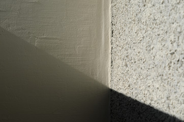 Seam Between Different Plaster Wall Textures. Diagonal Falling Shadow on the Walls. Fine Art Abstract Background