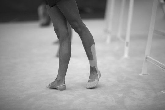 Legs gymnasts in the choreographic position in the rehearsal room in training