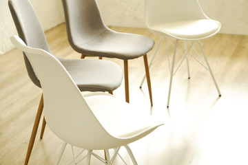 Group therapy counseling for addicts & alcoholics concept. Multiple loft style empty chairs, white...