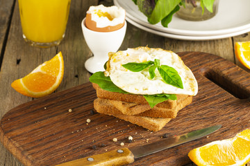Fototapeta na wymiar Scrambled eggs with herbs on wheat-rye crispy bread, homemade