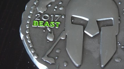 Closeup on a medal from a Spartan Beast dirty race on a table