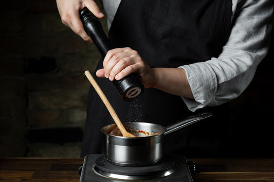 Close-up of the hands of a chef holding pepper mill