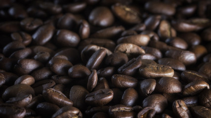 roasted coffee beans on wood texture close up.