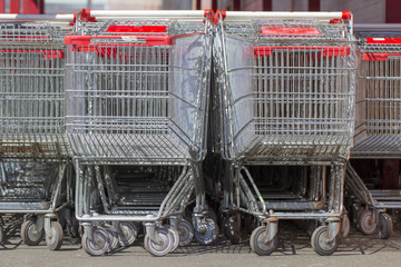 Supermarket shopping carts in a row in large supermarket store parking