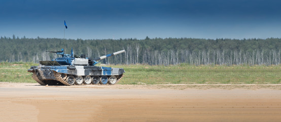 Military or army tank ready to attack and moving over a deserted battle field terrain. a lot of...