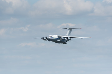 Four-engine heavy cargo plane in the sky. The plane to extinguish fires. Big water tank inside.