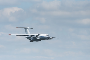 Four-engine heavy cargo plane in the sky. The plane to extinguish fires. Big water tank inside.