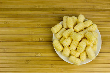 Corn on a plate. Wooden table. Salty food for beer
