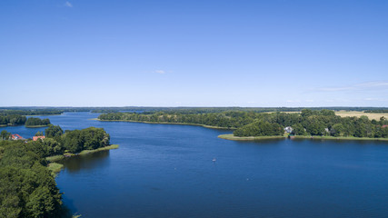 Aerial view of a country side with agricultural fields iand a lake. Beautiful landscape.  Captured from above with a drone