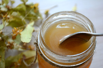 Honey in a transparent jar on the table. Spoon in a jar of honey
