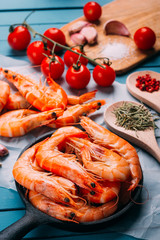 High angle view of blue wooden table full of prawns and some ingredients for seasoning and vegetables to mix them, concept of recipes and restaurants