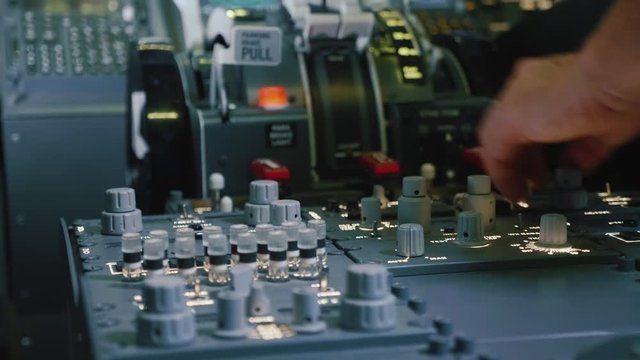 Panel of switches on an aircraft flight deck. Pilot controls the aircraft.