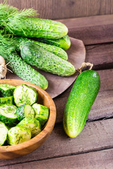 Freshly salted cucumber pickled with garlic and dill in a wooden plate. Rustic style