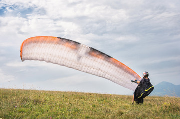 The paraglider opens his parachute before taking off from the mountain in the North Caucasus....